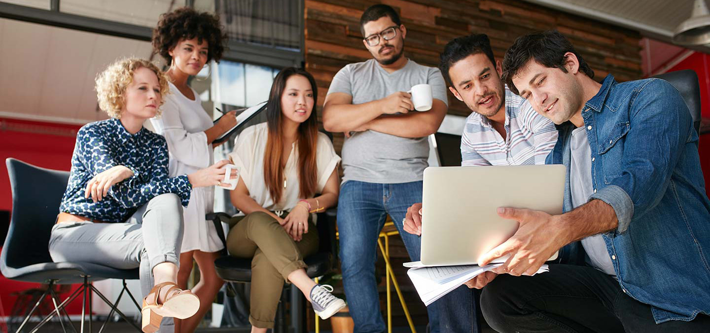 three women and three men agile team meeting around a laptop